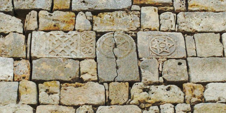 Каменные плиты со звёздами, вмурованные в стену.