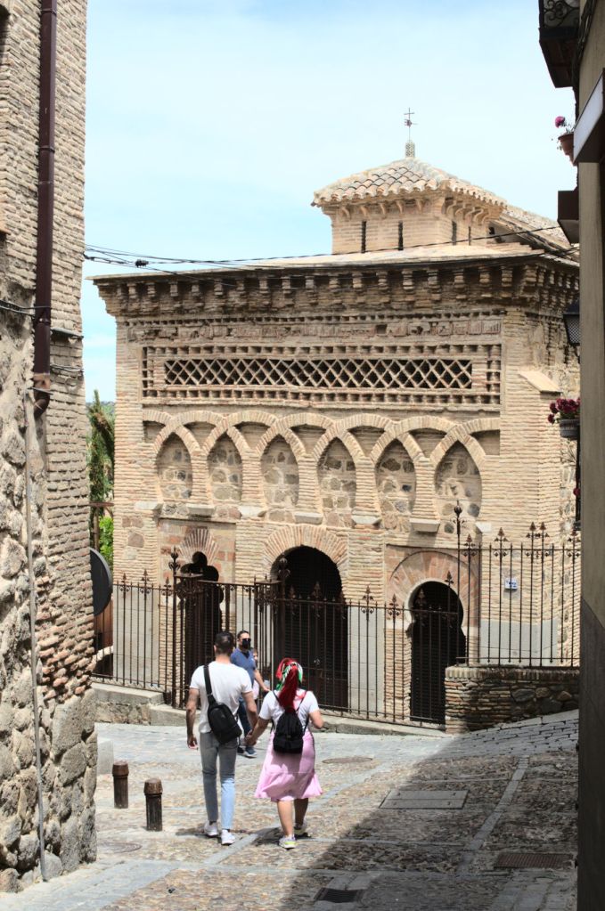 Главный фасад мечети Кристо-де-ла-Люс и идущая в его сторону парочка.