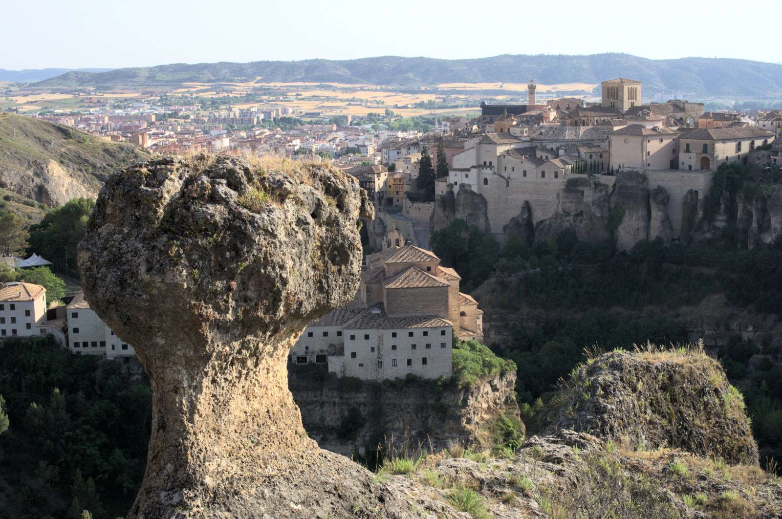 Скала в форме гриба на фоне города