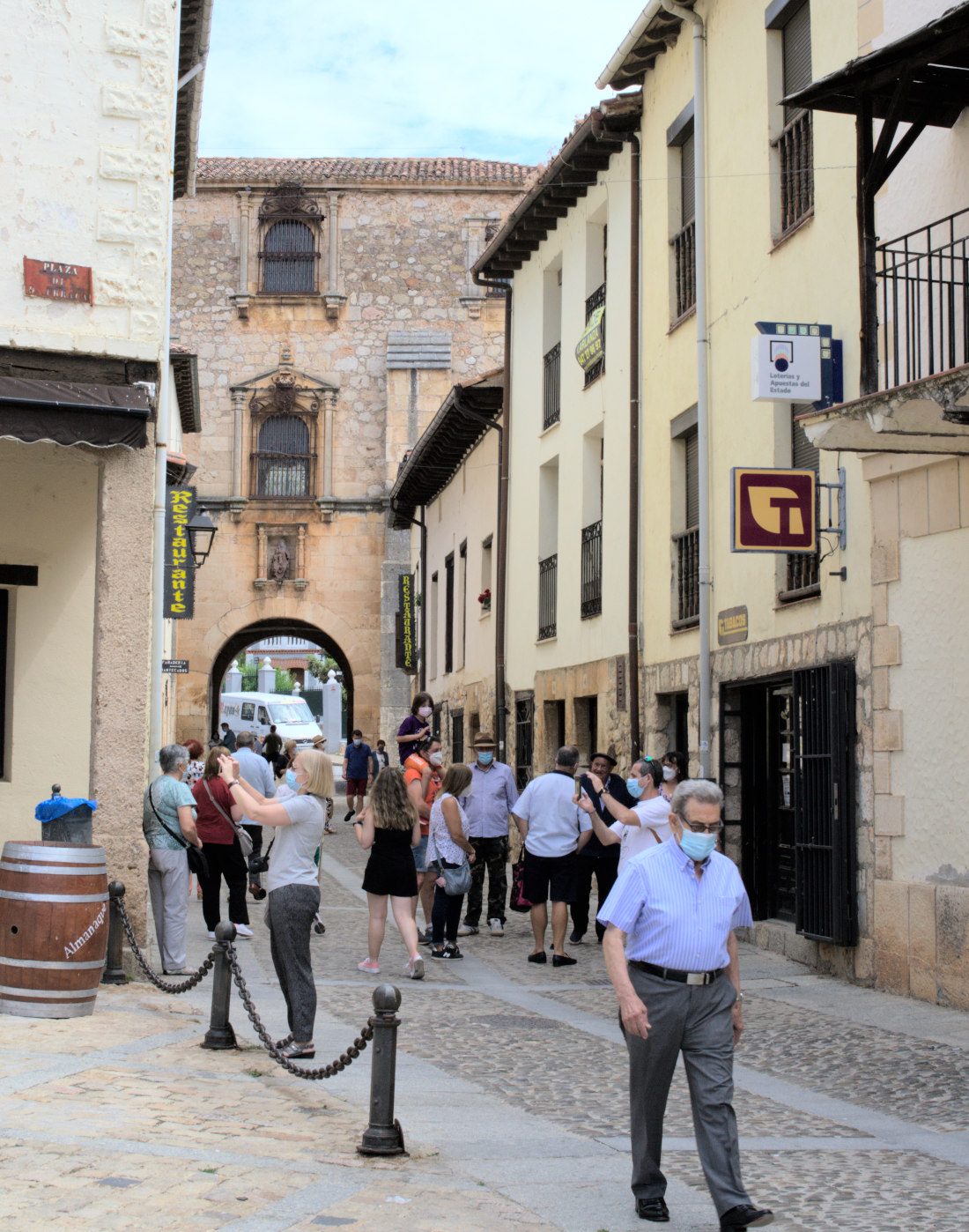 Люди на улочке, заканчивающейся аркой.