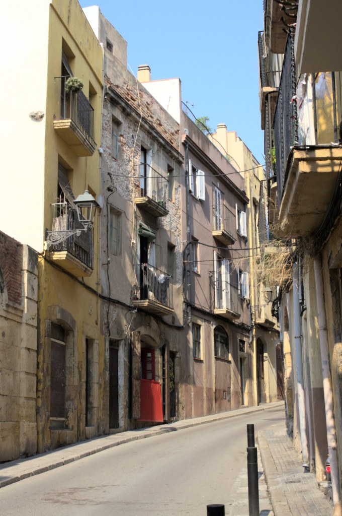 Фасады домов и загибающаяся узенькая улица