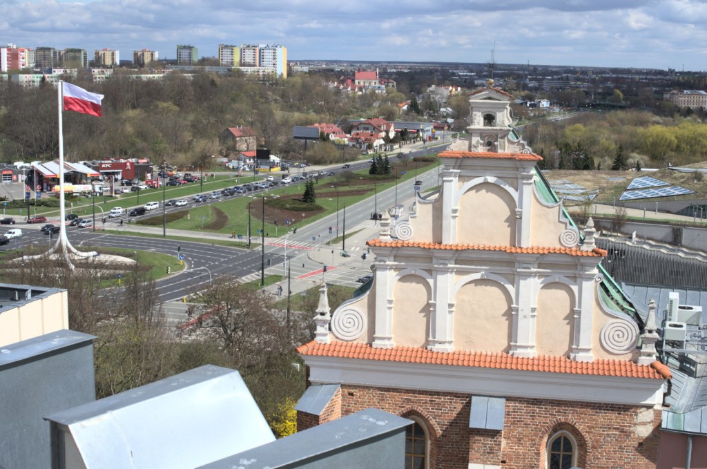 Верхняя часть часовни на фоне площади с польским флагом