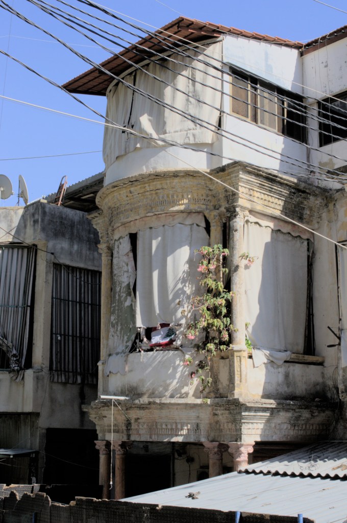 Старый особняк с завешенными от солнца балконами.
