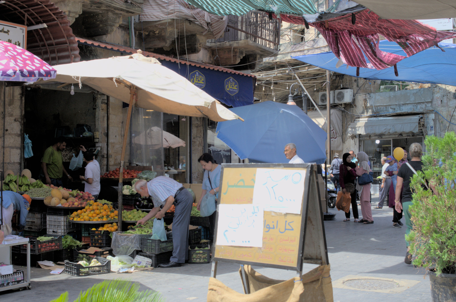 Люди покупают овощи и фрукты на базаре