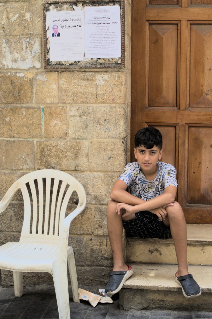 Мальчик сидит на ступеньках у входа в дом