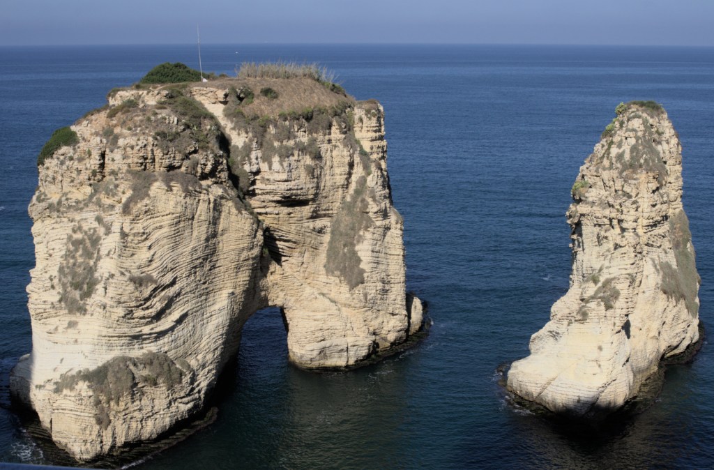 Две скалы посреди моря, одна из них с отверстием в нижней части