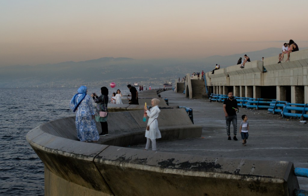 Люди фотографируются и гуляют у моря