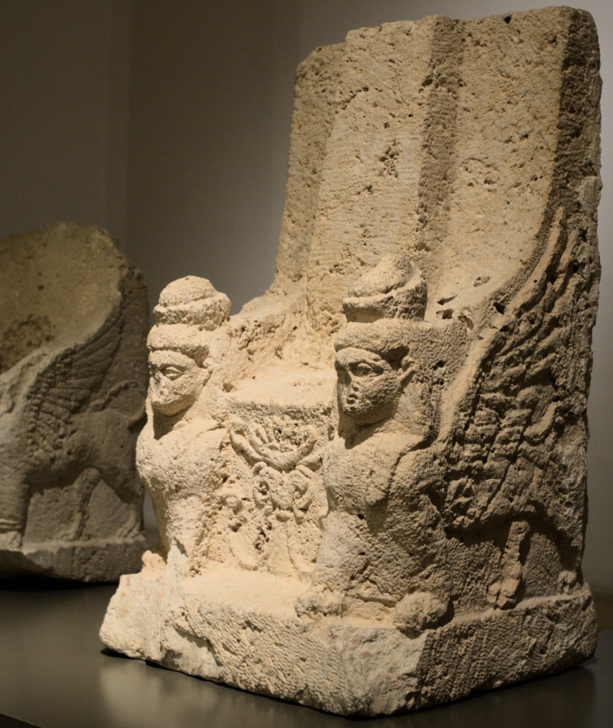 Каменное сиденье с фигурами сфинксов по бокам