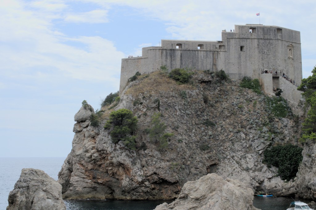 Крепость из серого камня венчает скалистый остров