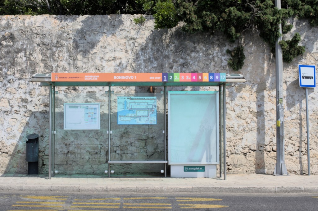 Лёгкая прозрачная конструкция остановки, освещённая солнцем