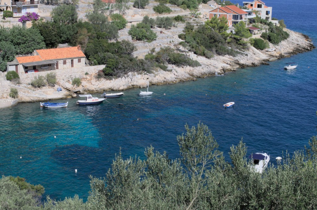 Невысокие скалистые берега окаймляют бухту с чистой сине-голубой водой