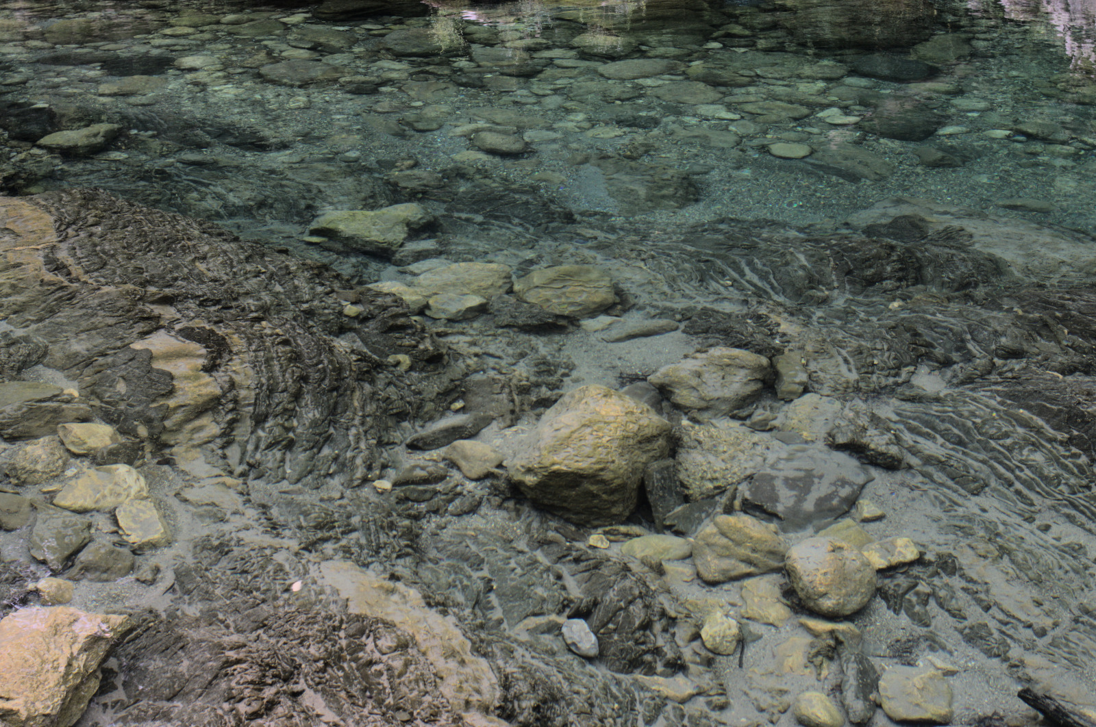 Каменистое дно видно сквозь прозрачную воду