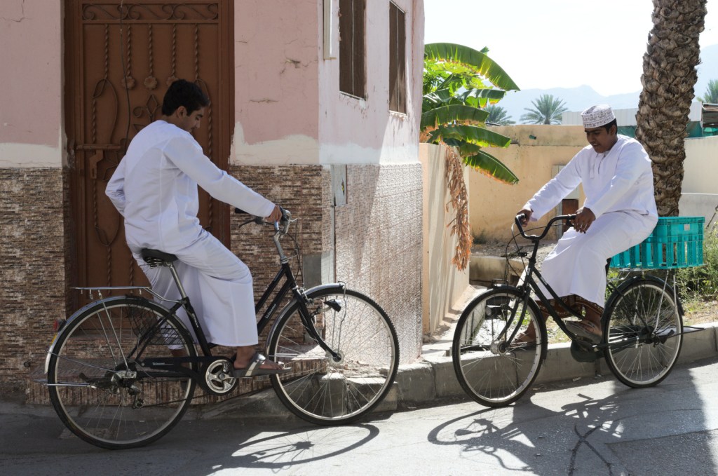Два юных велосипедиста в оманских нарядах
