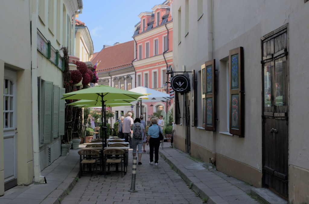 Тенистая улица со столами и зонтиками