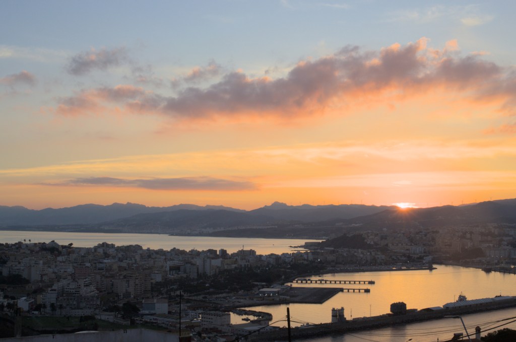 Город на полуострове, солнце заходит за горы