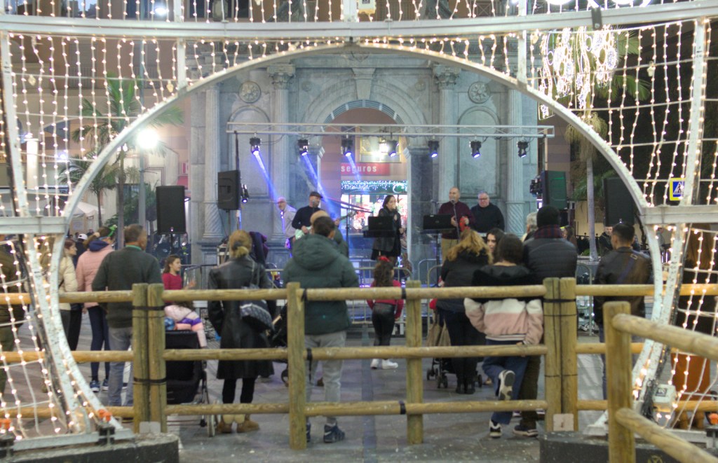 Музыканты выступают на сцене перед аркой-памятником