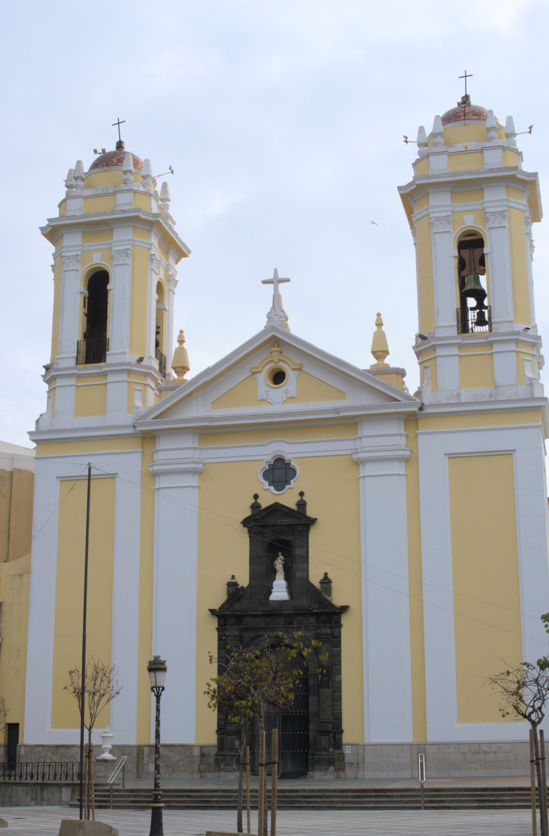 Неоклассическое здание с двумя башнями, выкрашенное в жёлтый и белый цвета