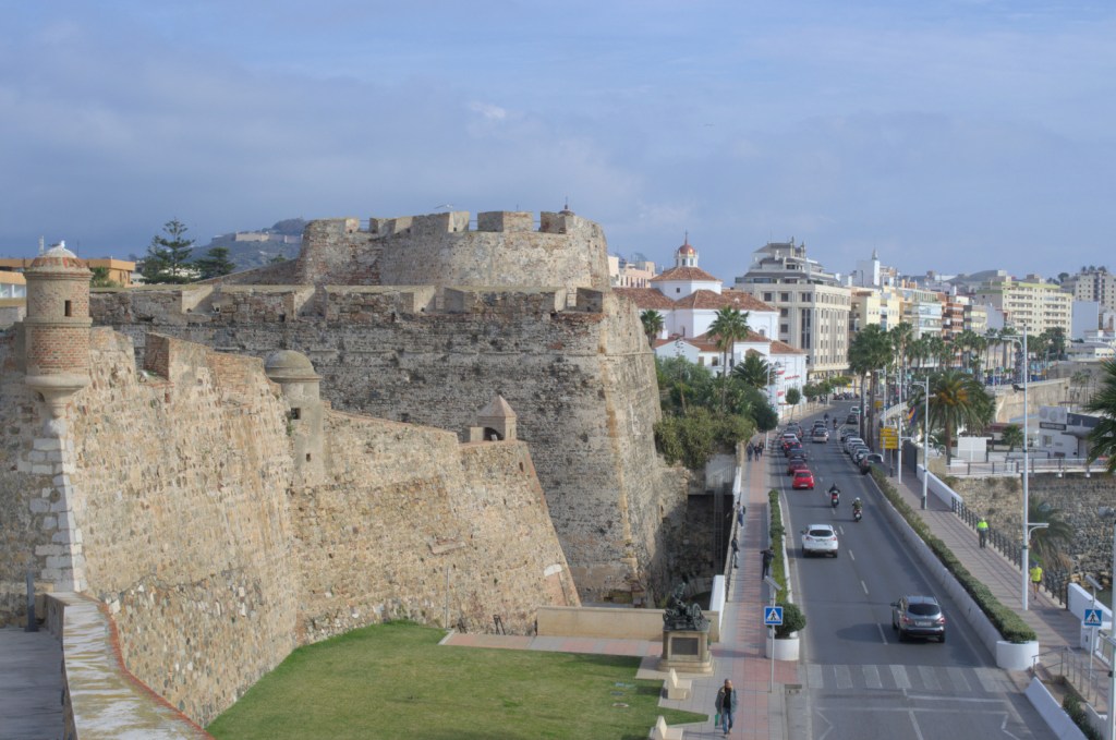 Крепостные стены, под ними набережная, немного дальше церковь и дома