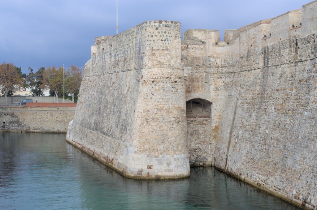 Мощные крепостные стены, ров, заполненный водой